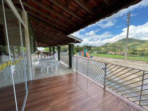a balcony of a house with a table and chairs at Chácara Deus Proverá in Socorro