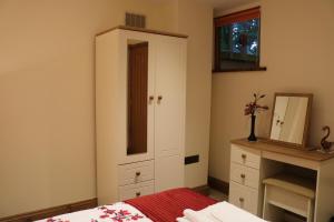 a bedroom with a cabinet and a bed and a dresser at The Old Chapel, The Cloisters in Gristhorpe +2 photos