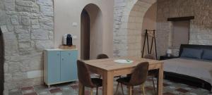 a room with a table and chairs and a bed at Maison Stelas in Bisceglie