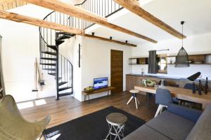 a loft conversion with a staircase and a living room at Apartments Mitterhof 1544 in Brunico