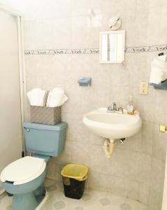 a bathroom with a blue toilet and a sink at Olímpica - Departamento Arcoíris - 5 Min Malecón in Mazatlán