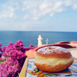 a donut sitting on a plate next to the ocean at Villa il Faro - Circeo holiday house in San Felice Circeo +45 photos