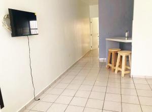 a kitchen with a refrigerator and a table and stools at Olímpica - Departamento Arcoíris - 5 Min Malecón in Mazatlán +3 photos