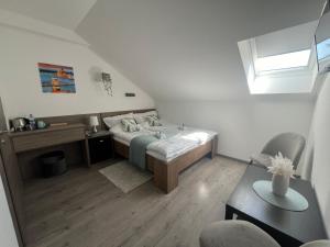 a bedroom with a bed and a desk and a window at Sophia Apartman Gödöllő in Gödöllő