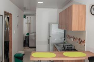 a kitchen with a table and a refrigerator at GURUS FR| Apto Central, estilo, con King Size Bed in Pereira