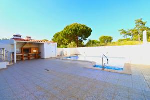 a house with a swimming pool next to a white wall at Casa da Audiência Lote 32 in Monte Gordo