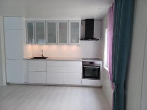 a kitchen with white cabinets and a sink at Great Guest House Natalie's in Skjervøy