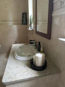 a bathroom sink with a candle and a mirror at Apartament nad Brdą in Tuchola