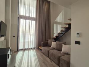 a living room with a couch and a large window at Meraviglia Boutique Hotel in Sarandë