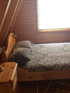 a small bed in a room with a window at Banjska brvnara in Vrnjačka Banja