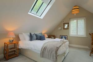 a bedroom with a large white bed with a window at Musthay Mews Tockington cottage in Bristol