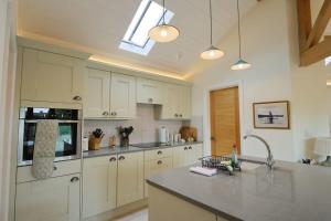 a kitchen with white cabinets and a counter top at Musthay Mews Tockington cottage in Bristol