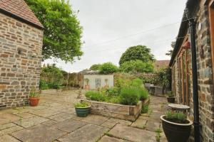 a courtyard in a house with potted plants at Musthay Mews Tockington cottage in Bristol