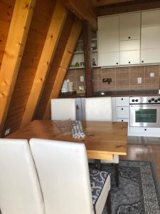 a kitchen with a wooden table and white cabinets at Banjska brvnara in Vrnjačka Banja
