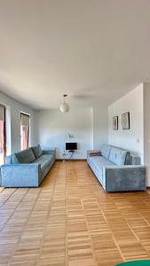 Dos sofás azules en una sala de estar con suelo de madera. en Słoneczny Hel, en Hel