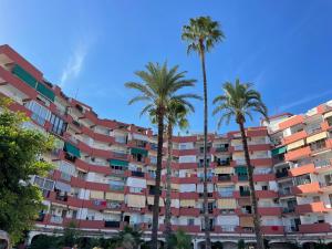 a tall building with palm trees in front of it at Apartamento Montgo in Jávea +2 photos