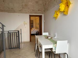 a dining room with a white table and white chairs at B&B Margherita in Putignano