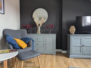 a living room with a chair and a mirror at Ferienwohnung Coburg, familienfreundlich und stilvoll in Coburg