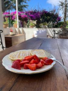 a plate of pancakes and strawberries on a table at Dimora Storica Villa Pasquale Capri in Capri