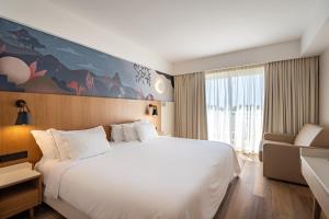 a hotel room with a large white bed and a couch at Onyria Quinta da Marinha Hotel in Cascais