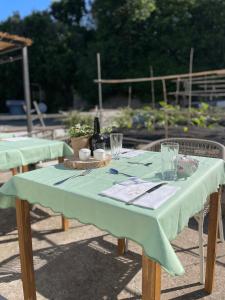 a table with a green table cloth and a bottle of wine at Dimora Storica Villa Pasquale Capri in Capri