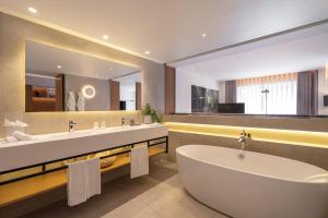 a bathroom with two sinks and a tub and a mirror at Onyria Quinta da Marinha Hotel in Cascais