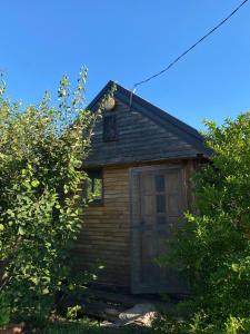 a small wooden house with a door and trees at Bungalovi1885 Kosic in Danilovgrad