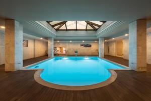 a large swimming pool in a building with a ceiling at Onyria Quinta da Marinha Hotel in Cascais