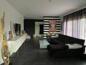 un salon avec un canapé noir et une table dans l'établissement Maison villa avec piscine, à Sadirac