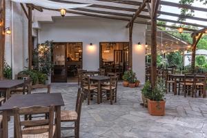 an outdoor patio with tables and chairs and a pergola at KissosInn in Kissos