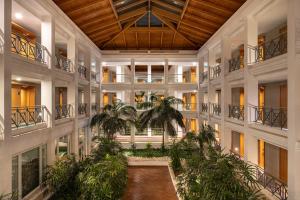 an indoor courtyard with palm trees in a building at Onyria Quinta da Marinha Hotel in Cascais