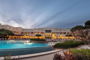 a resort with a swimming pool and a building at Onyria Quinta da Marinha Hotel in Cascais