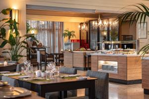 a restaurant with tables and chairs and a kitchen at Onyria Quinta da Marinha Hotel in Cascais
