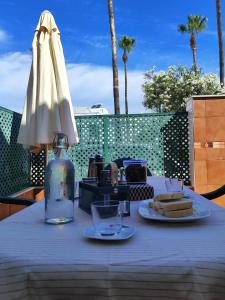 a table with a plate of bread and an umbrella at La Longuera - Playa Cruz del Mar in Chipiona