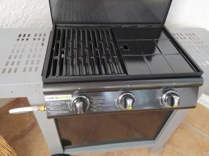 a gas grill in a kitchen with its door open at Studio de la pinède in Nissan-lez-Enserune +35 photos