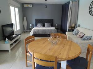 a living room with a table and a bed at Studio de la pinède in Nissan-lez-Enserune