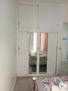 a room with white cabinets and a bed and a mirror at Elbernoussi in Casablanca