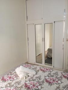 a bedroom with a mirror and a bed with flowers at Elbernoussi in Casablanca