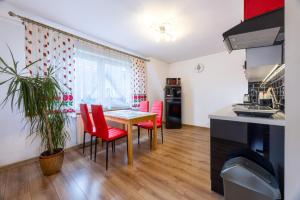 a kitchen with red chairs and a table in a kitchen at Apartament u Sabiny i Stanleya in Bukowina Tatrzańska