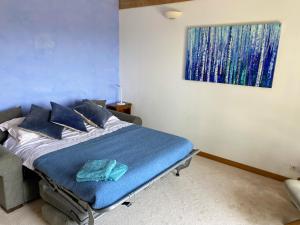 a bed in a room with a painting on the wall at Poulou Pyrénées in Gelos