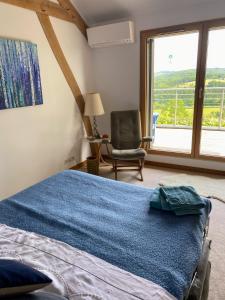 a bedroom with a bed and a chair and a window at Poulou Pyrénées in Gelos