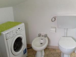 a bathroom with a washing machine and a toilet at Casa vacanza toscana in Fivizzano