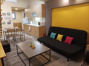 a living room with a couch and a kitchen at The Urbanite in Kavála