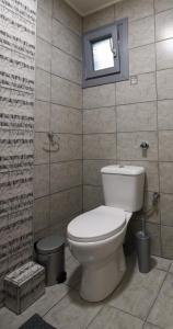 a bathroom with a toilet and a window at The Urbanite in Kavála
