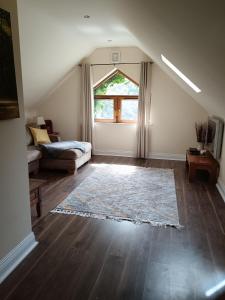 a living room with a couch and a large window at Victoria's Countryside Apartment in Mallow