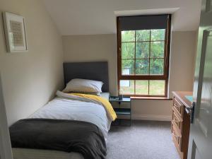 une chambre avec un lit, un bureau et une fenêtre dans l'établissement Kenmare Holiday Cottage, à Kenmare