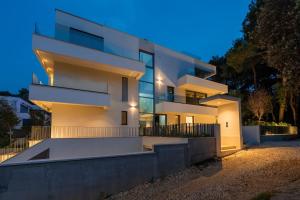 a large white building with lights on it at night at The Q Bliss - your new 4-star hideaway with a garage in Rovinj