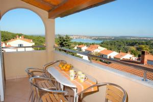 a balcony with a table and chairs and a view at Apartments Tanja in Premantura