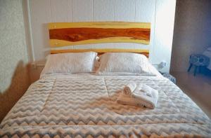 a bedroom with a bed with towels on it at Hotel e Pousada Cabanas Arbor in Ametista do Sul