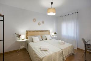 a white bedroom with a bed with two towels on it at Apartamento turístico Ana, con garaje y bonitas vistas in Arróniz +30 photos